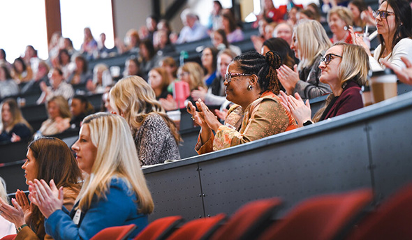 a large group of attendees sitting at the women lead conference listing to one of the keynotes