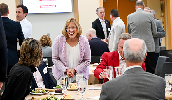 Dean Kathy Farrell speaking to a group of people sitting at a table in Hawks Hall.
